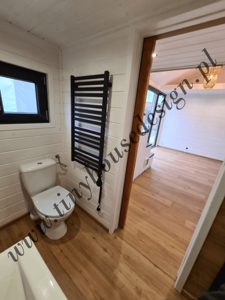Łazienka w domku Tiny House Design - toaleta i grzejnik łazienkowy