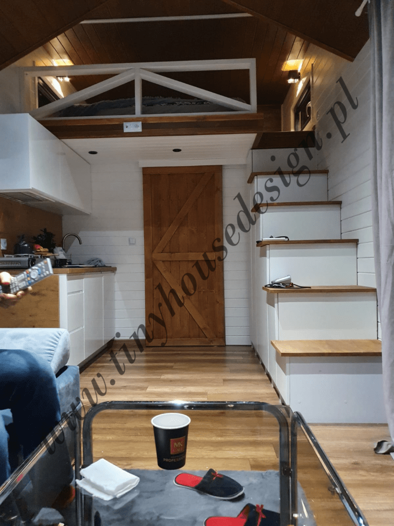 Aneks kuchenny i drzwi prowadzące do łazienki w domku Tiny House Design